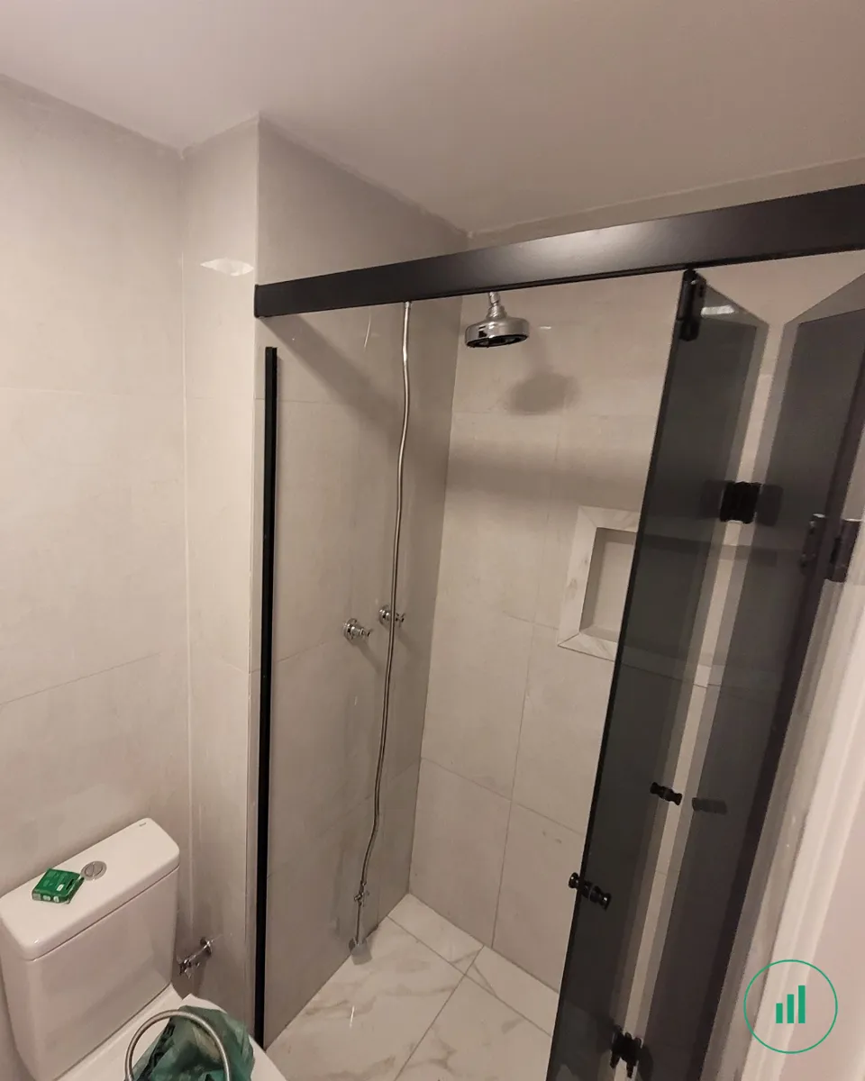 Apartamento reformado — banheiro com box de vidro fumê